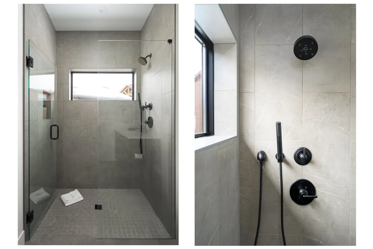 A modern, spa-inspired bathroom featuring a glass walk-in shower with a rain shower head, sleek black fixtures, and textured tiles. The space exudes tranquility and luxury.
